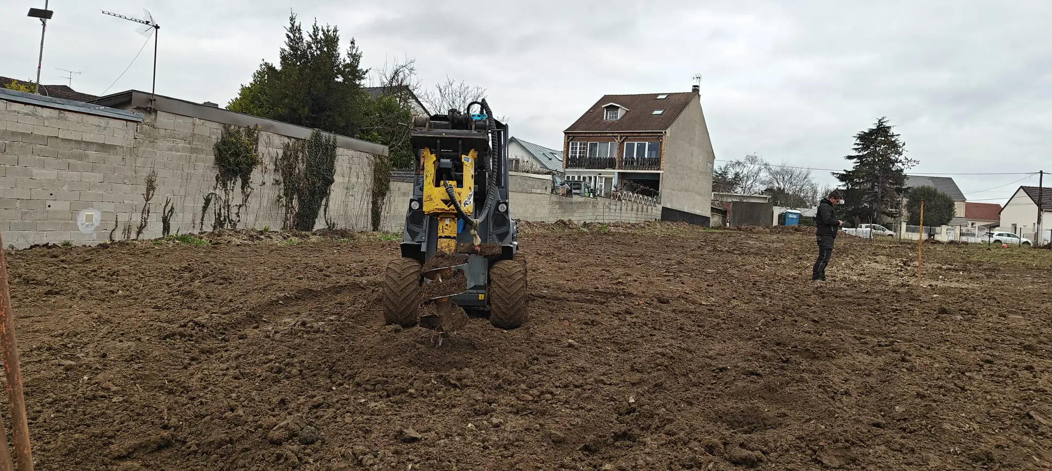 Une Tarrière grosse vis métallique est enfoncée dans le sol